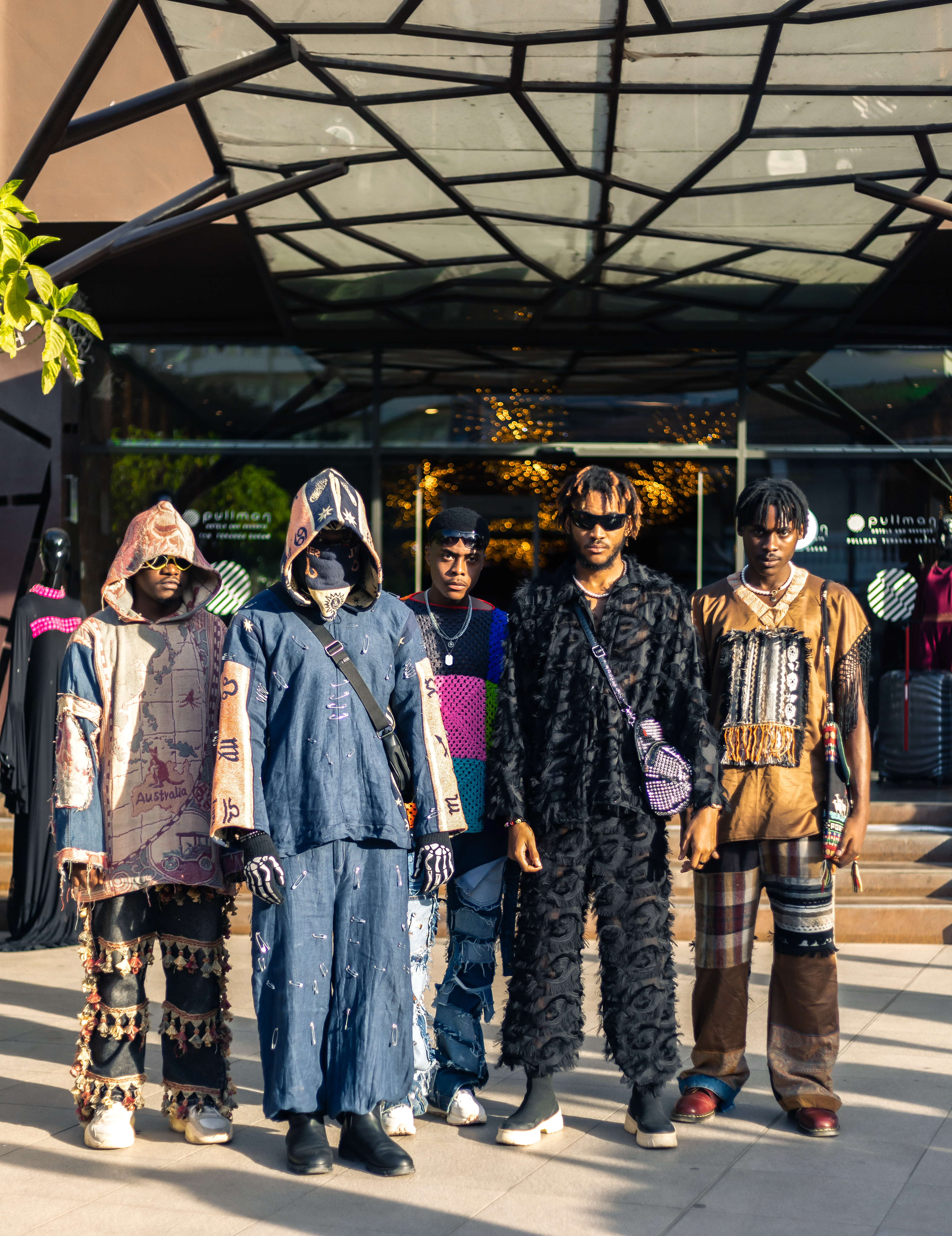 5 mannequin posant devant un bâtiment